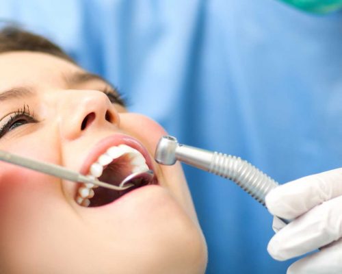 periodontist examining woman's teeth